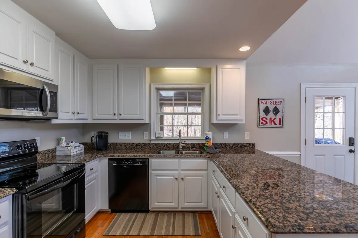The kitchen area features granite countertops, stainless steel appliances, and a bright window. The space is decorated with a ski-themed wall sign, adding a playful mountain retreat vibe. The scene exudes warmth and practicality, aligning with the section's mention of starter essentials and professionalism.